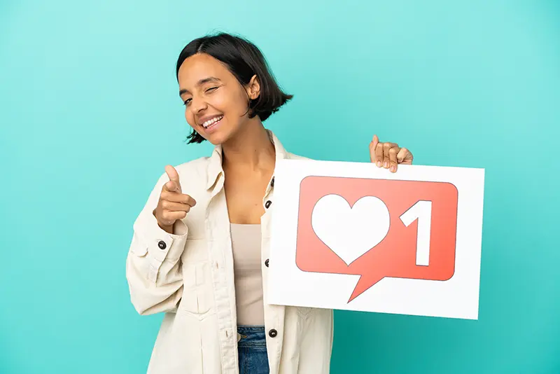 young-mixed-race-woman-isolated-blue-background-holding-placard-with-like-icon-pointing-front